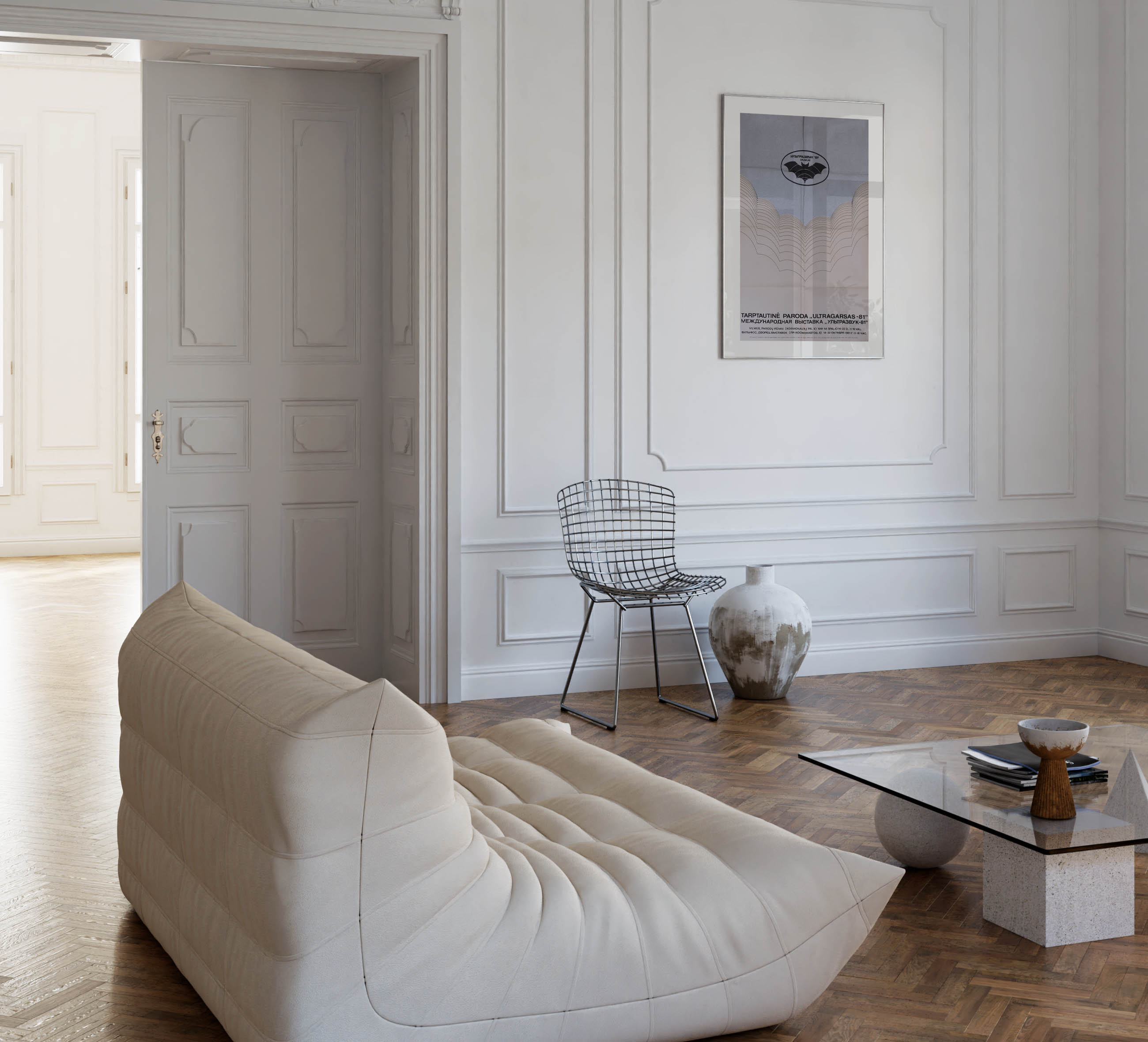 Modern living room with a low-profile cream sofa, wire frame chair, and the framed bat poster on a white paneled wall.